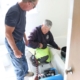 The owner of Break The Mold setting up his equipment in a bathroom while talking to the homeowner about the mold removal process.