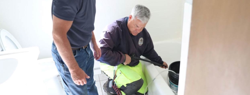 The owner of Break The Mold setting up his equipment in a bathroom while talking to the homeowner about the mold removal process.